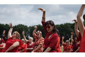 ケイト・ブッシュ・ファンが赤い服を着て集まり「嵐が丘」に合わせて