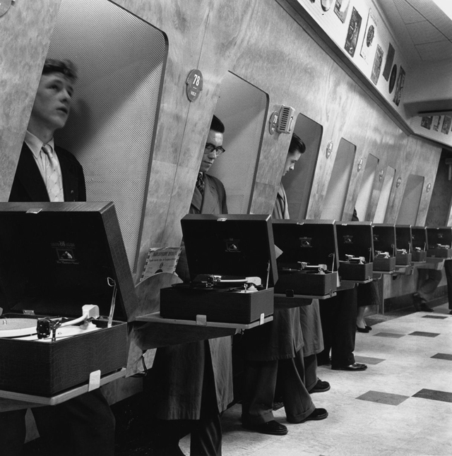 Customers listen to the latest record releases at a listening booth in the HMV shop at 363 Oxford Street, London, 24th November 1955. (John Drysdale/Keystone Features/Hulton Archive/Getty Images)