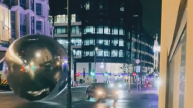 Giant runaway Christmas baubles tumble through London street