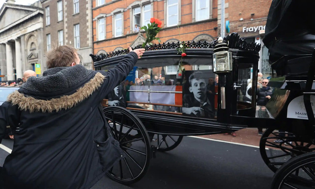 シェイン・マガウアンの柩に花を手向ける弔問者. Photograph: Liam McBurney/PA