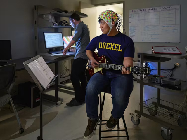 man plays guitar while his EEG is recorded - John Kounios/Creativity Research Lab/Drexel University, CC BY-ND